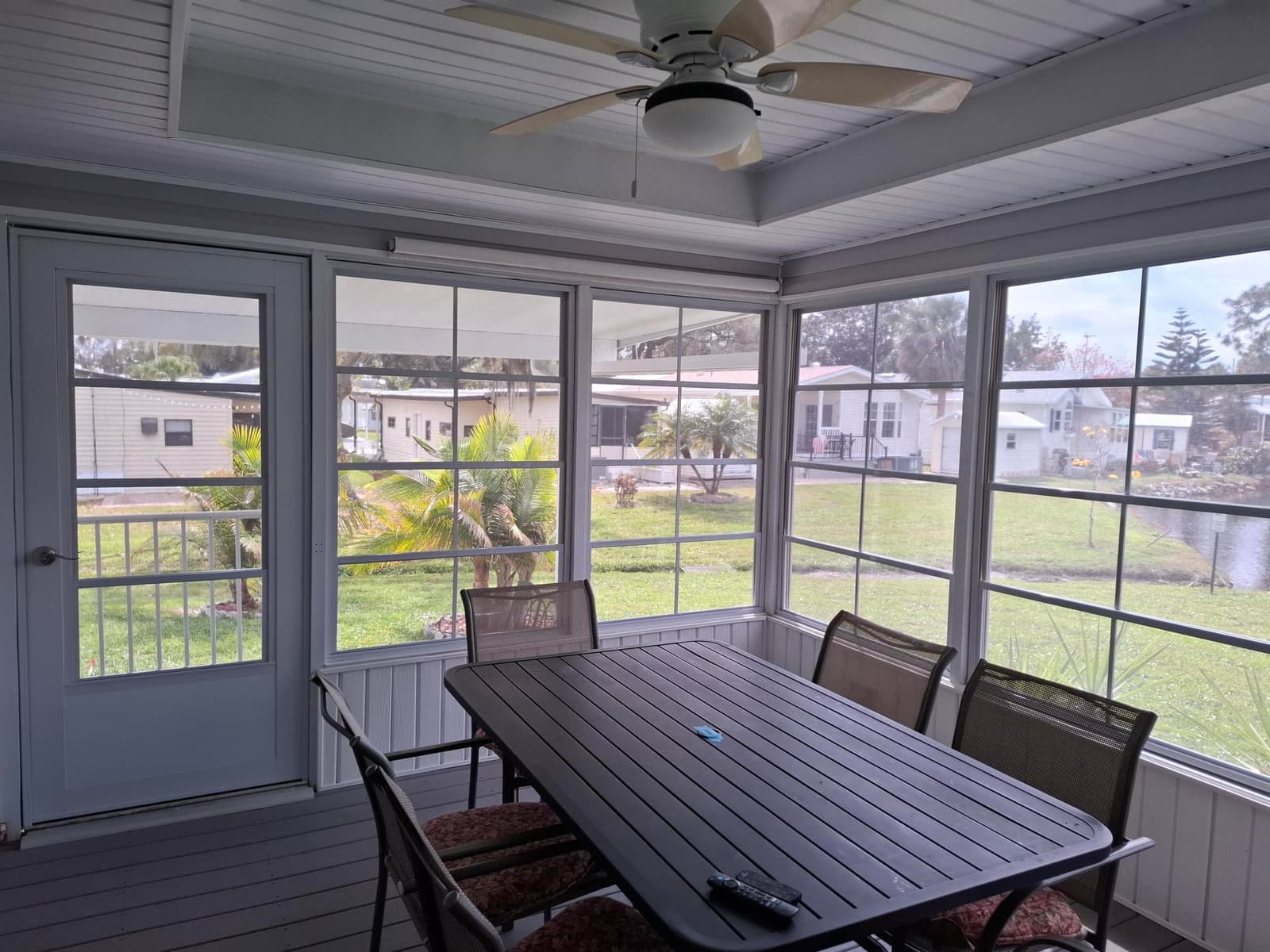 White vinyl porch windows overlooking a lake from inside an enclosed porch